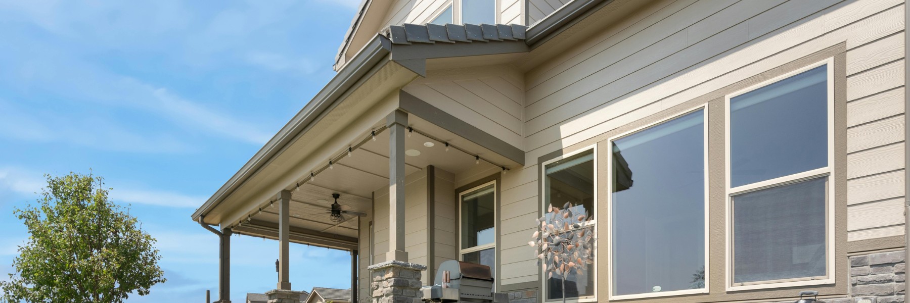 Home exterior with tan lap siding and a covered porch