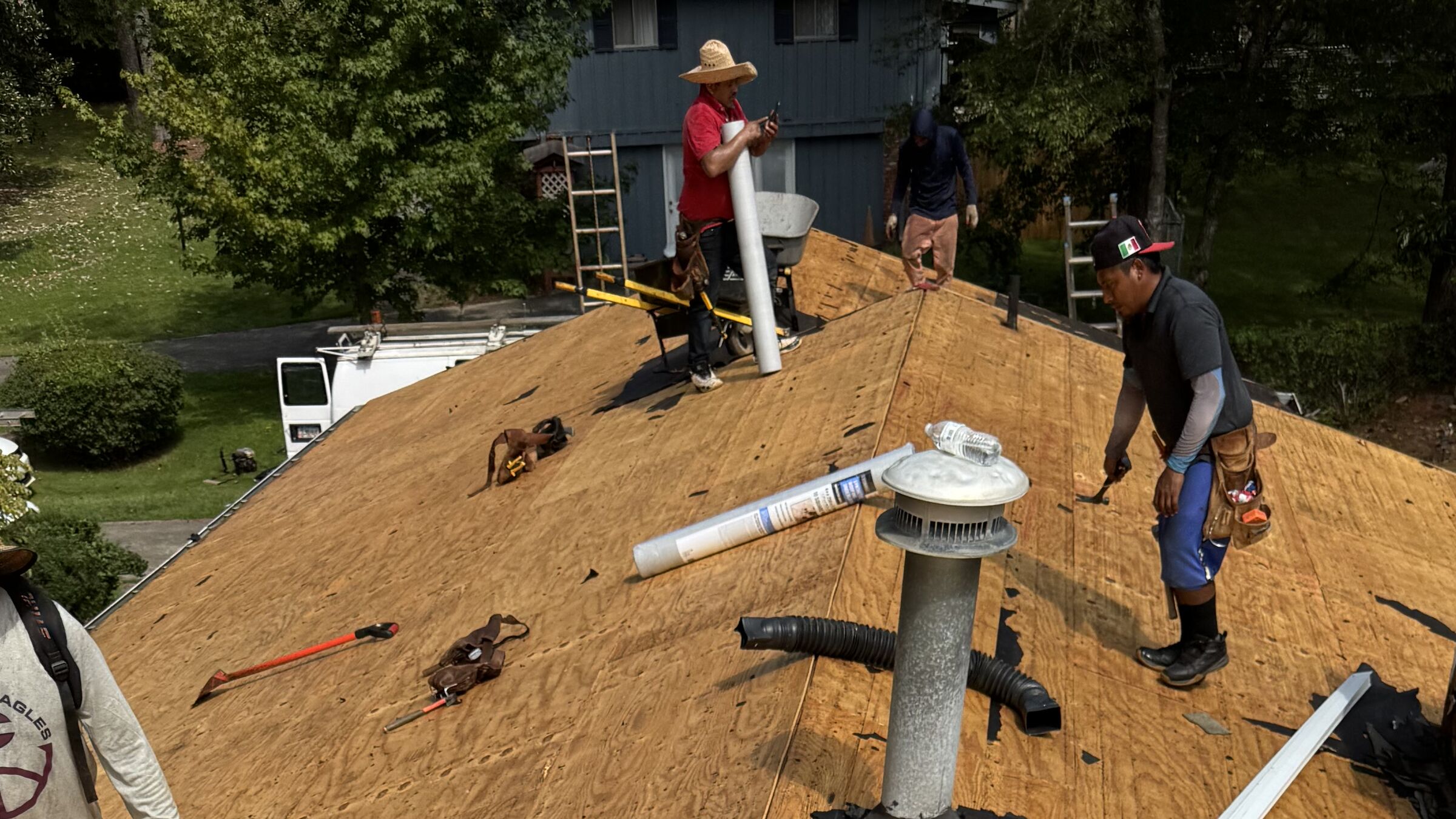 Roofing crew installing new decking and vents on a home